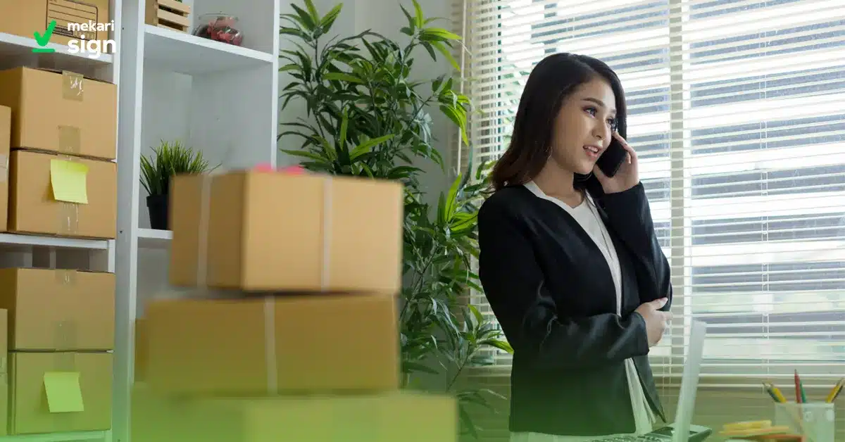 Seorang pebisnis wanita sedang mengatur proses procurement melalui telepon di ruang kerja